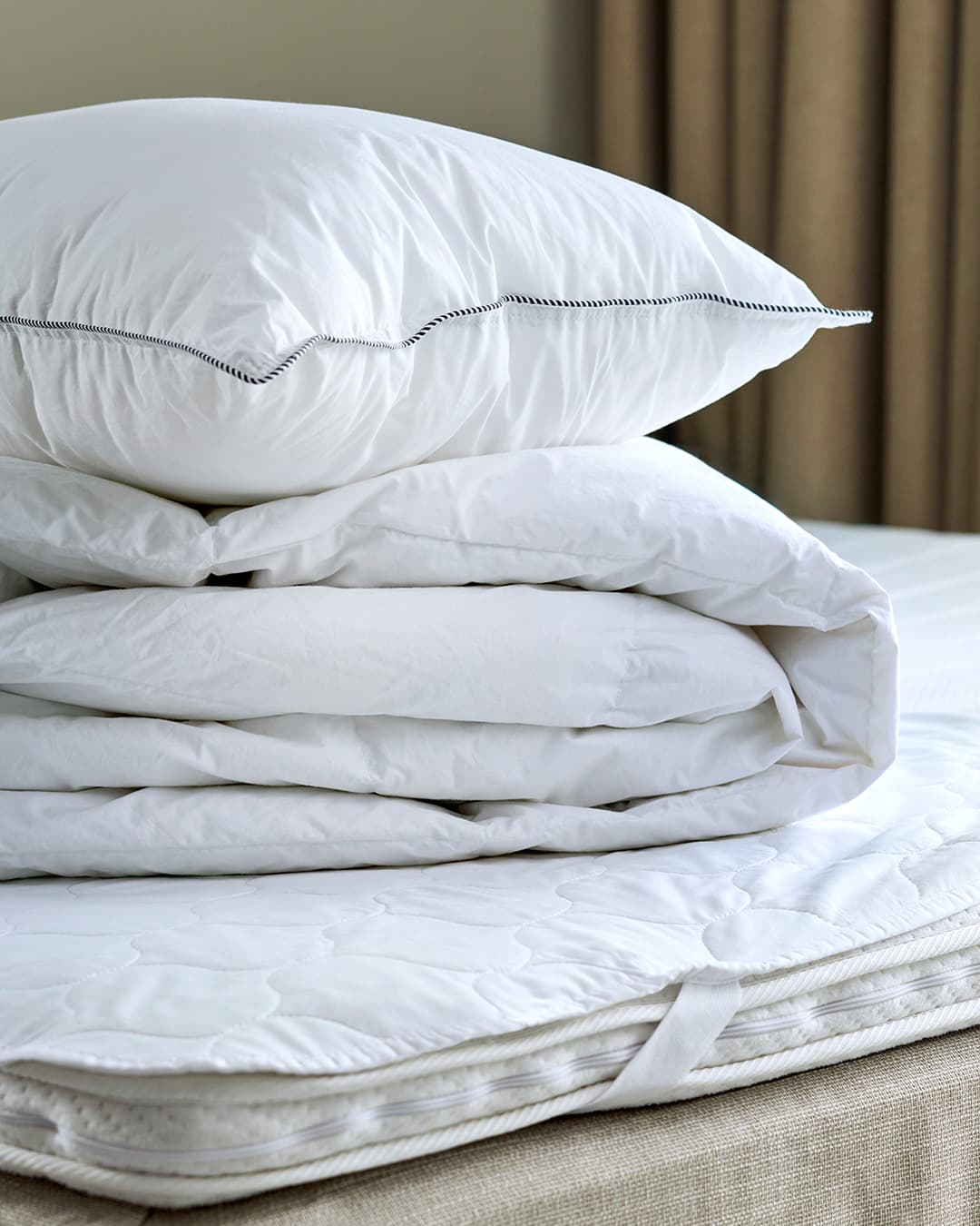 GRIPSHOLM - HÖG MED TÄCKEN OCH KUDDAR PÅ EN SÄNG MED MADRASSKYDD